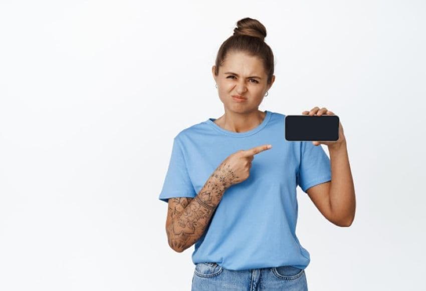 Девушка указівает пальцем на дисплей телефона