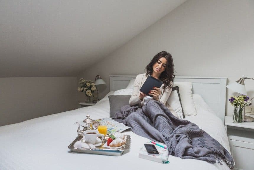 Молода жінка сидить на ліжку Молода жінка сидить на ліжку