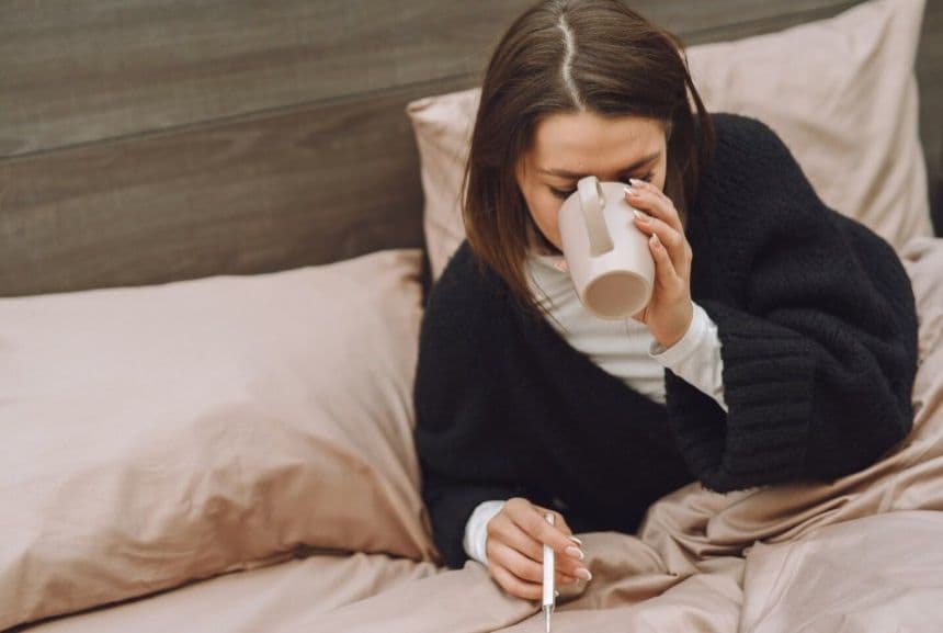 Хвора жінка п'є воду з чашки