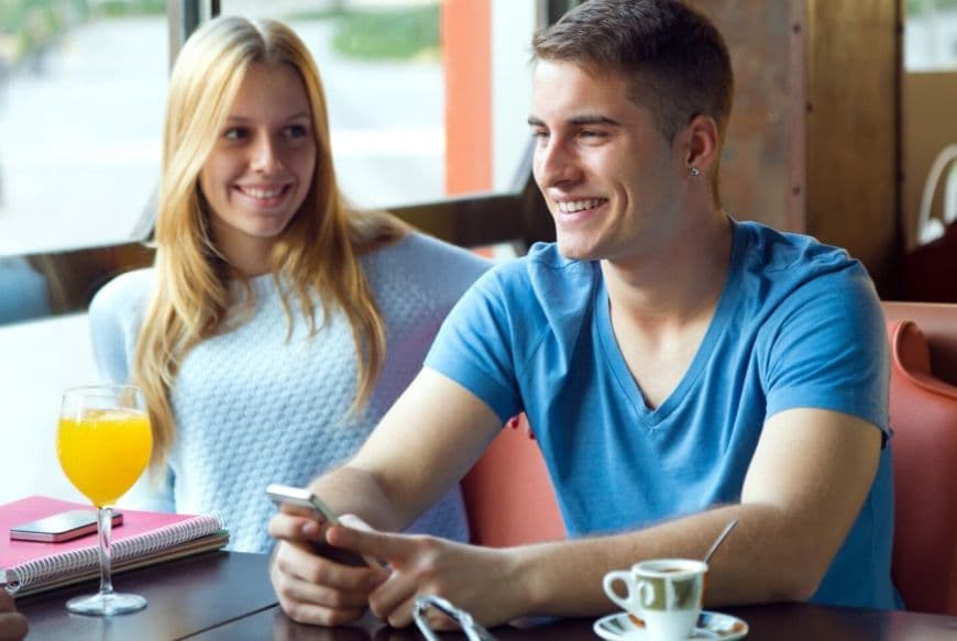 Девушка и парень общаются за столом в кафе Девушка и парень общаются за столом в кафе