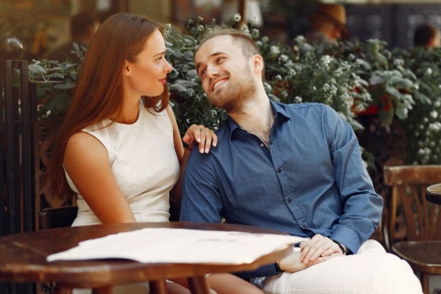 Девушка отвечает на вопросы парня в летнем кафе Девушка отвечает на вопросы парня в летнем кафе