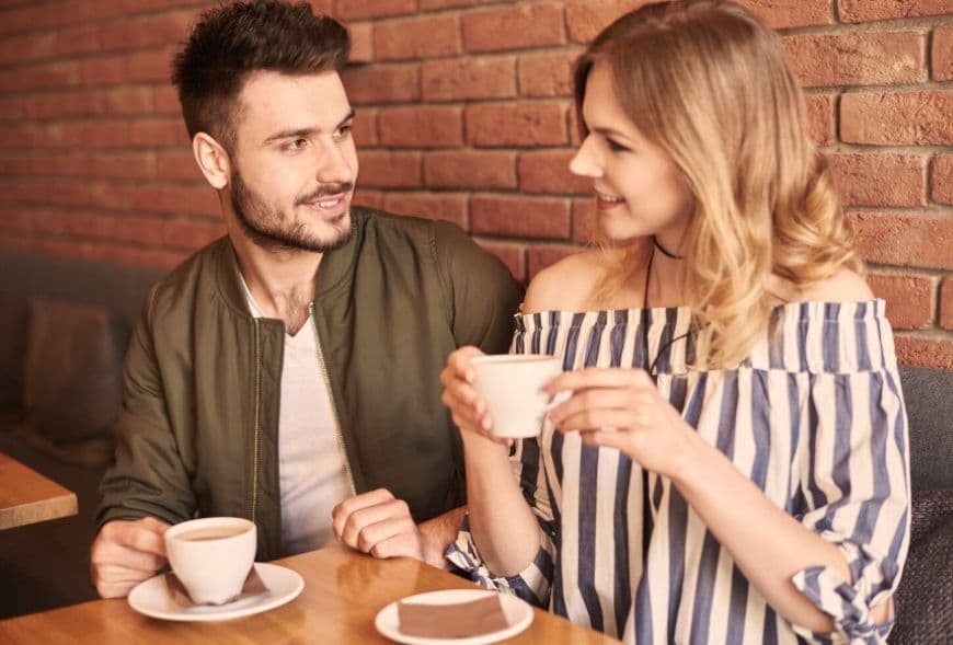 Девушка красиво отвечает на вопросы парня в кафе Девушка красиво отвечает на вопросы парня в кафе