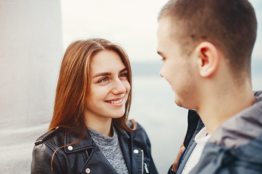 Парень и девушка улыбаясь смотрят друг на друга Парень и девушка улыбаясь смотрят друг на друга