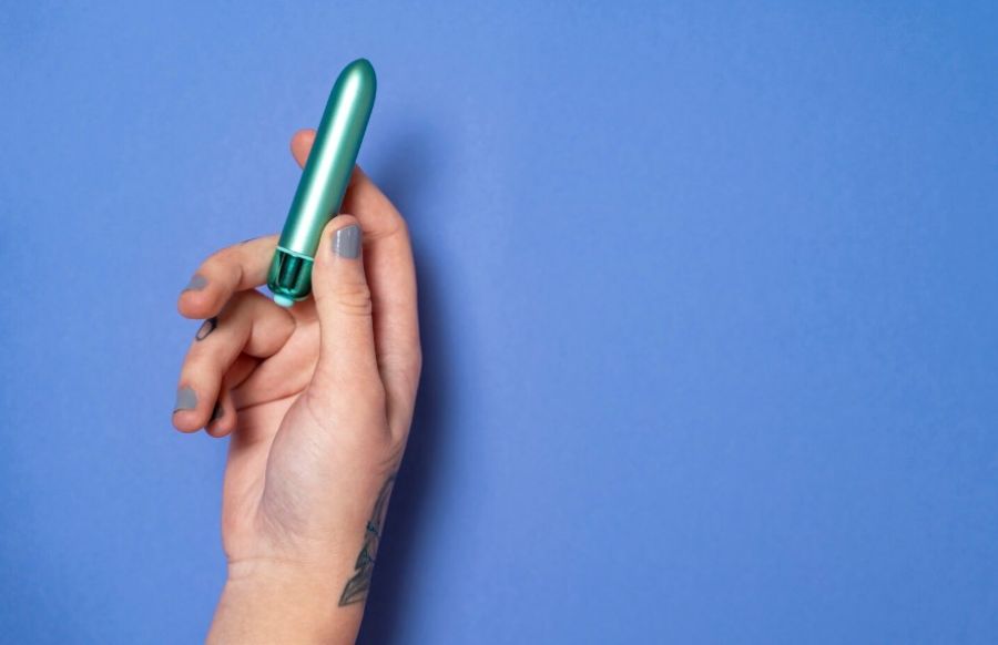 Жіноча рука тримає класичний маленький вібратор